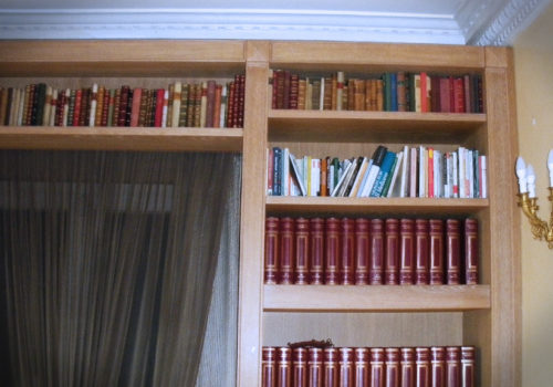 Libreria impellicciata con lesene e pareti bugnate. Sportelli in rovere massello, spazzolata e decapata con venature bianche